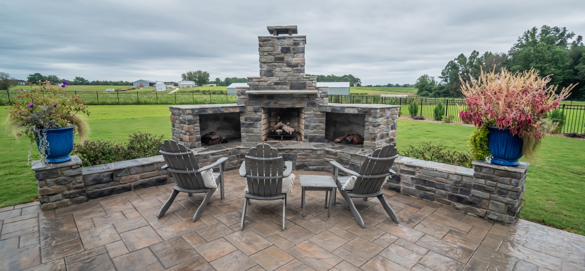 Nautral stone fire place outdoors with seating area on patio