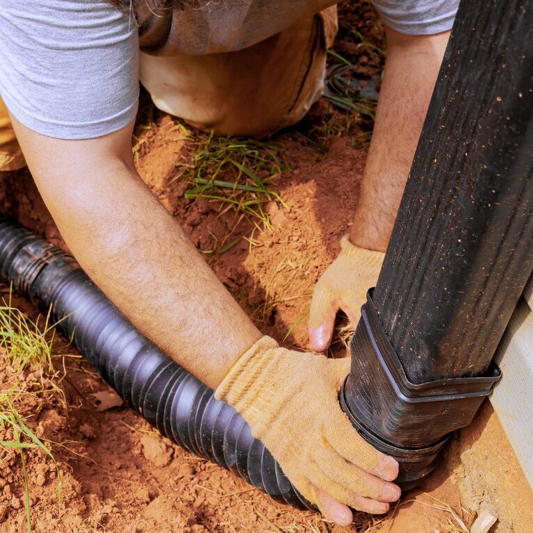 installing downspout from gutters into underground drain system