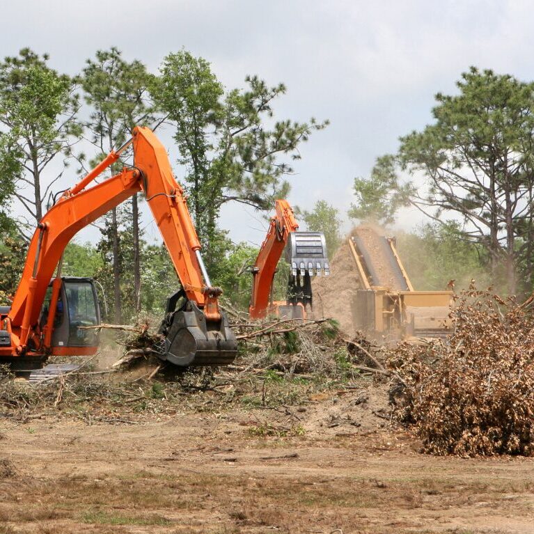 Heavy machinery being used to clear a plot of land